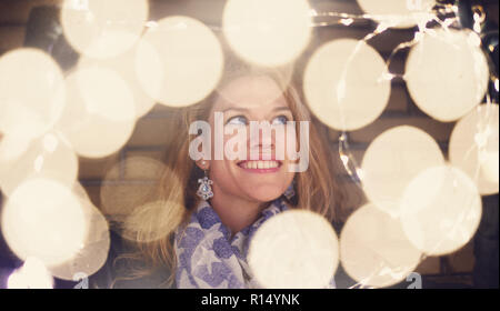 Jeune femme jouant avec fairy lights au winter outdoor Banque D'Images