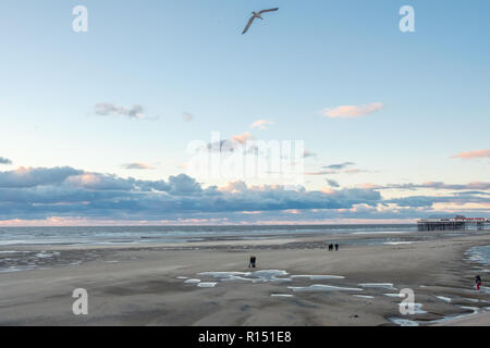 Promenade sur les touristes méconnaissable Blackpool plage au coucher du soleil pendant un week-end d'automne à la fin du mois d'octobre 2018. Blackpool est l'un des favoris Englands seasi Banque D'Images