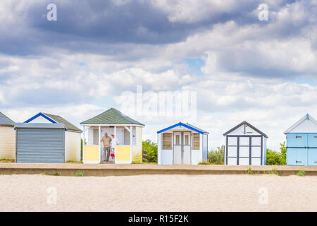 Vieux couple debout dans le porche d'une cabane de plage traditionnel anglais, Mer du Nord, Sutton-sur-Mer, Lincolnshire, Angleterre, RU Banque D'Images