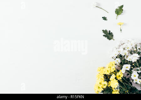 Top View bouquet de belles fleurs jaune avec des feuilles vertes sur fond blanc, télévision lay. Un minimum d'arrangement de fleurs avec copie espace. Banque D'Images
