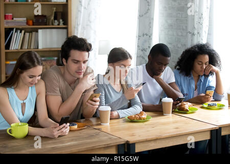 Divers Les amis se réunit au café passe temps libre la communication en ligne, la navigation sur Internet au lieu de conversation en direct le souhaitez smartphones. L'abus ou wir Banque D'Images