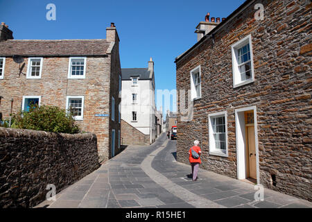 Maisons anciennes en grès Stromness, Orkney avec pierres de pavage d'une carrière locale et de galets pierres dans le centre de la rue. Banque D'Images