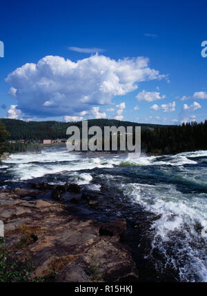 La Suède, Norrbotten, Pitealven Rivière, vue vers le bas Storforsen Rapids 25 miles au nord ouest d'Alusbyn ville. Étendue d'eau à courant rapide multiplication des bâtiments au-delà et fond de forêt dense. Une chute de 80 mètres à un rythme de 800 000 litres par seconde sur 4 kilomètres. Banque D'Images