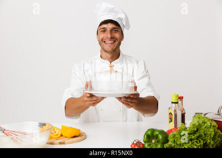 Image de beau jeune homme chef isolated over white wall background la cuisson. Banque D'Images