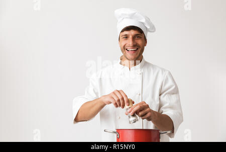 Image de beau jeune homme chef isolated over white wall background la cuisson. Banque D'Images