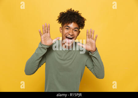 Portrait of smiling african man screaming coiffure afro chic d'avoir ou d'appeler plus isolé sur fond jaune Banque D'Images