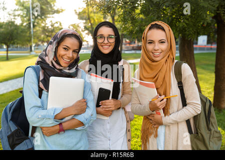 Image d'une jeune femme arabe les étudiants titulaires d'livres à l'extérieur du parc. Banque D'Images