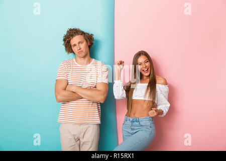 Portrait d'un jeune couple debout sur deux arrière-plan coloré, femme célèbre Banque D'Images