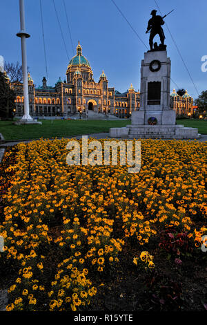 Des massifs de fleurs devant les édifices du Parlement et le Monument de la guerre de Corée au crépuscule, Victoria, BC, Canada Banque D'Images