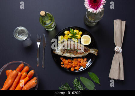 Un repas sain : la brème de mer, poêlée de carottes et pommes de terre au four Banque D'Images