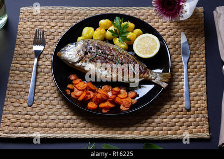 Un repas sain : la brème de mer, poêlée de carottes et pommes de terre au four Banque D'Images