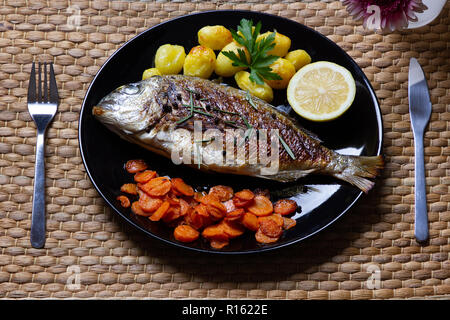 Un repas sain : la brème de mer, poêlée de carottes et pommes de terre au four Banque D'Images