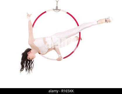 Une jeune femme exécute les éléments acrobatiques dans l'anneau d'air. Des performances en studio sur fond blanc. Banque D'Images