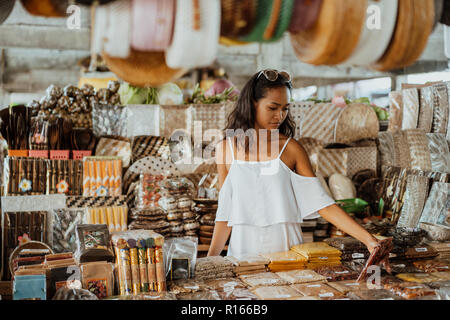 Femme Asiatique avec la peau tannée à la boutique de souvenirs Banque D'Images