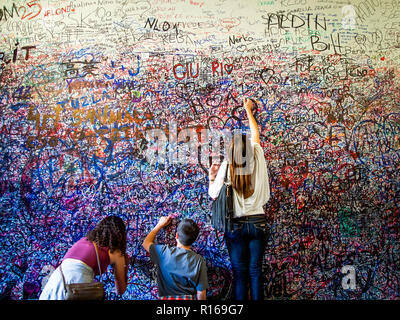 Les touristes la rédaction des messages sur le mur de la maison de Juliette à Vérone, Italie Banque D'Images