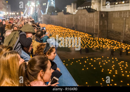 Londres, Royaume-Uni. Nov 9, 2018. Les foules de l'appartement donne sur la Tour de Londres au-delà de l'aggravation de la cérémonie d'ombre, où le fossé est rempli progressivement avec des milliers de flammes : d'une loi publique du souvenir pour la vie de l'armée déchue. Il commence par une procession dirigée par le gardiens Yeoman de la Tour de Londres qui solennellement la lumière la première flamme. Sélectionnez une équipe de volontaires, puis procéder à la lumière du reste de l'installation, créer progressivement un cercle de lumière, irradiant de la tour. Crédit : Guy Bell/Alamy Live News Banque D'Images