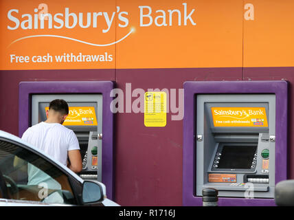 Un homme est vu en utilisant le distributeur de billets au supermarché Sainsbury's à Londres. Les supermarchés et magasins de proximité n'auront plus à payer des millions de livres dans les taux d'affaires pour les distributeurs à l'extérieur de leurs magasins, à la suite d'un arrêt de la Cour d'appel. Depuis 2010 les supermarchés et magasins de proximité ont été tenu de payer les tarifs sur les machines et la Cour d'appel a estimé qu'environ 300 millions de livres a été déjà chargée et doit désormais être remboursés. Les boutiques qui vont bénéficier immédiatement : Sainsburys et Tesco, qui avait pris l'affaire en appel. Banque D'Images