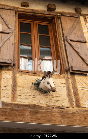 Caricature d'un cheval ou tête d'âne sous la fenêtre d'un bâtiment médiéval le timbre à Belvès,France Banque D'Images