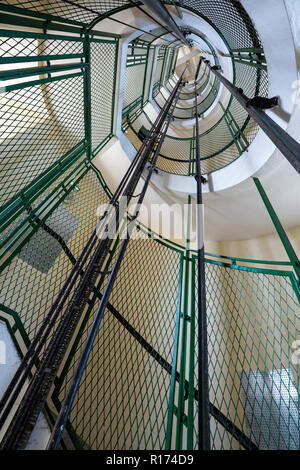 En colimaçon avec rails de l'élévateur dans le phare de Cap Fréhel, Bretagne, France Banque D'Images