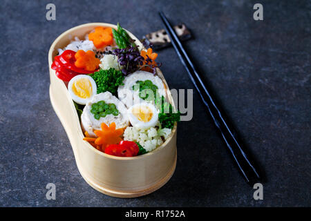 Boîte bento japonais avec du poulet farci aux asperges, riz, légumes et oeufs de caille Banque D'Images