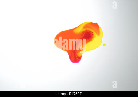 Flaque translucide de couleur orange, jaune et rouge sur fond blanc Banque D'Images