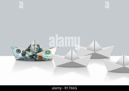US dollar note papier ordinaire et bateaux origami, fond gris Banque D'Images
