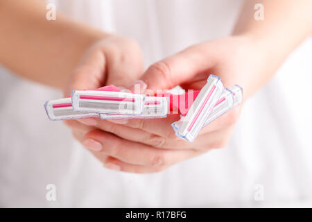 Rasoirs femme rose dans les mains sur le fond blanc. Série de rasoirs sur fond blanc. Les rasoirs jetables pour femmes rose Banque D'Images