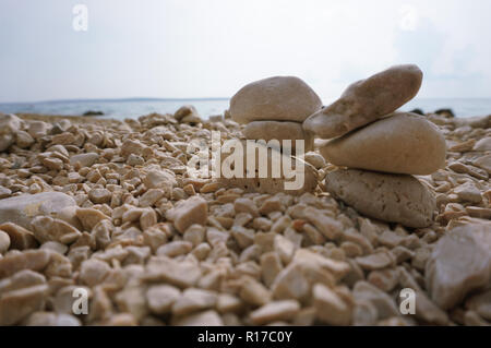 Paire de cairn de pierre sur la plage de galets sur un jour nuageux Banque D'Images