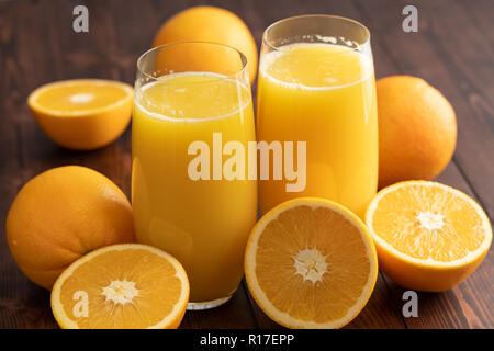 Deux verres de jus d'orange avec des oranges sur la table en bois Banque D'Images