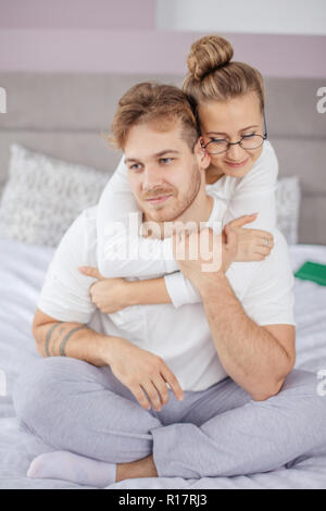 Bonne recherche couple embrasse passionnément, s'assied sur le lit confortable Banque D'Images