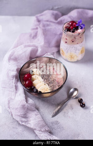 Smoothy savoureux pour le petit-déjeuner avec chia sur fond violet et violet avec banane, cerise, cassis et Banque D'Images