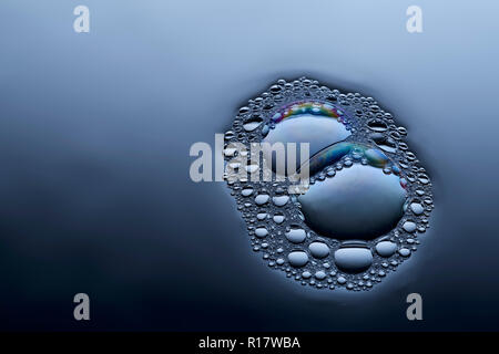 Vue rapprochée de la fusion des bulles sur la surface liquide Banque D'Images