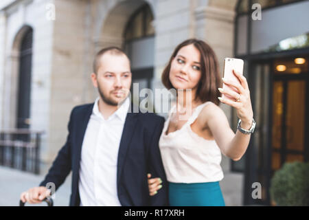 D'affaires élégant couple avec téléphone et réservez à l'hôtel de d'attente dans l'aéroport. Business travel concept Banque D'Images