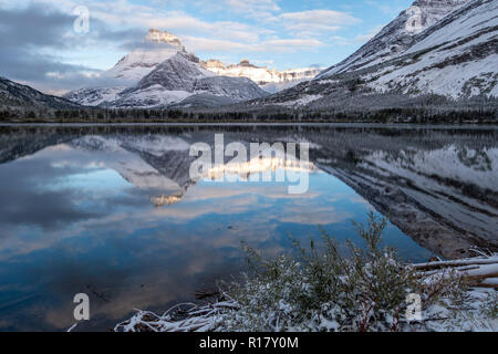 Mt Henkel compte dans Swiftcurrent Lake au début de l'aube lumière après une tempête de neige. Le Glacier National Park, Montana Banque D'Images