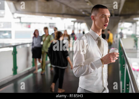 Les jeunes homosexuels androgyne LGTB businessman drinking coffee Banque D'Images