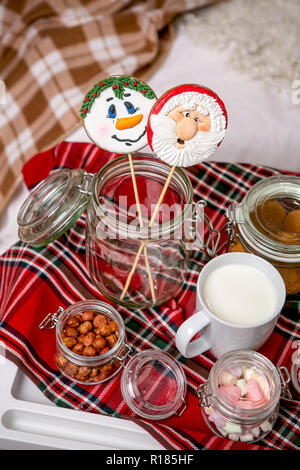 Bonhomme de pain d'épice et Santa sur un bâton sur la table du petit déjeuner dans la chambre. Maison de bonbons. Nouvel An et Noël. Ambiance de fête. Banque D'Images