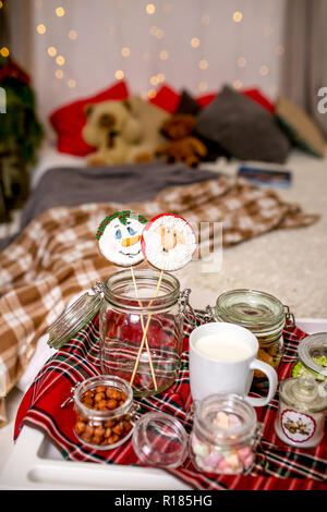 Bonhomme de pain d'épice et Santa sur un bâton sur la table du petit déjeuner dans la chambre. Maison de bonbons. Nouvel An et Noël. Ambiance de fête. Banque D'Images