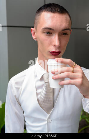 Les jeunes homosexuels androgyne LGTB businessman drinking coffee Banque D'Images