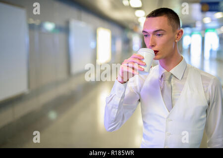 Les jeunes homosexuels androgyne LGTB businessman drinking coffee Banque D'Images