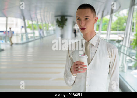 Les jeunes homosexuels androgyne LGTB businessman drinking coffee Banque D'Images