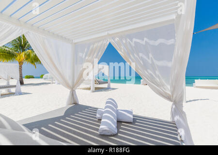 Scène de plage tropicale étonnante avec auvent blanc et de rideaux de luxe pour l'Été Espace détente concept. Ciel bleu avec du sable blanc pour sunny beach landscape Banque D'Images