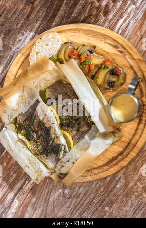 Loup de mer cuit servi avec légumes grillés et champignons Banque D'Images