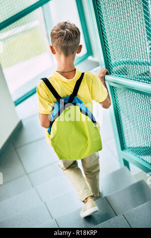 Vue arrière du sac à dos écolier avec descendre au couloir d'école Banque D'Images
