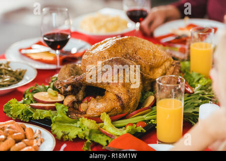 Gros plan de la Turquie sur le plateau entouré de nombreux plats sur la table de Thanksgiving Banque D'Images