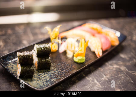 Rouleaux de sushi et un arrière-plan, le cadre noir, vue de dessus. Set de cuisine restaurant japonais coloré, copy space Banque D'Images