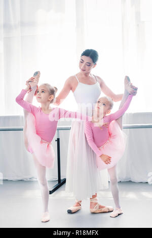 Jeune professeur de ballet l'exercice avec les petites ballerines en ballet school Banque D'Images