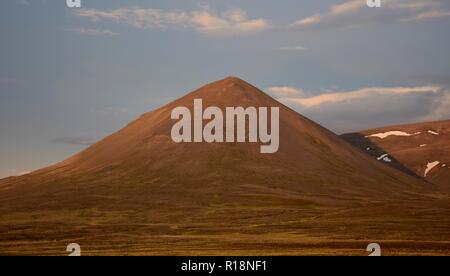 Le songe d'une nuit en Islande. Une montagne est allumé dans le soleil de minuit. Le Svinadalsfjall près de Blönduos. Un fond de ciel bleu. Banque D'Images