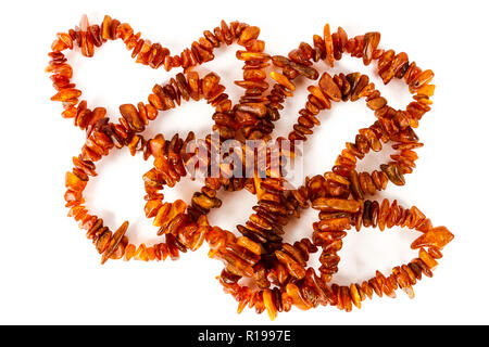 Chaîne de perles d'ambre baltique isolé sur fond blanc. Collier ambre orange vif de matières perles en un tas. Banque D'Images