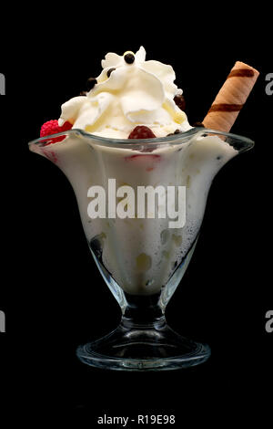 La crème glacée avec des framboises dans un beau verre sur un fond noir Banque D'Images