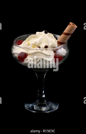 La crème glacée au chocolat et gelée de framboise vanille avec des boules de stick dans un beau verre sur un fond noir Banque D'Images